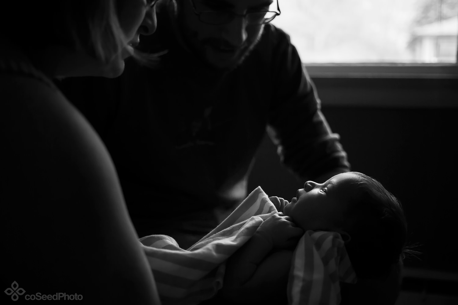 New parent Nicole and Matt stare in wonder at the miracle of their new baby.