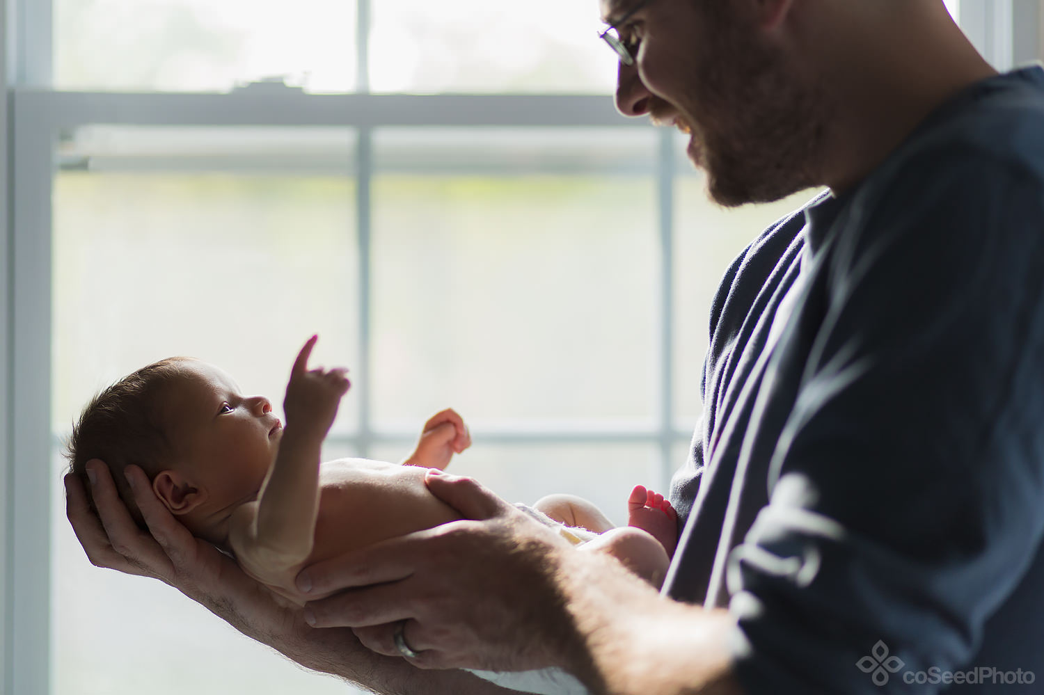 Dad holds newborn Declan on his forearm.
